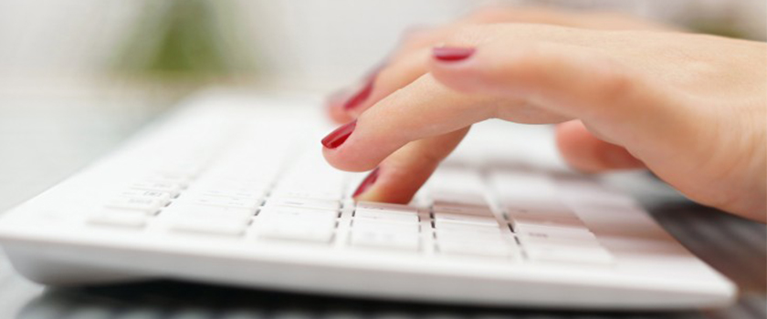 Woman typing on computer keyboard.